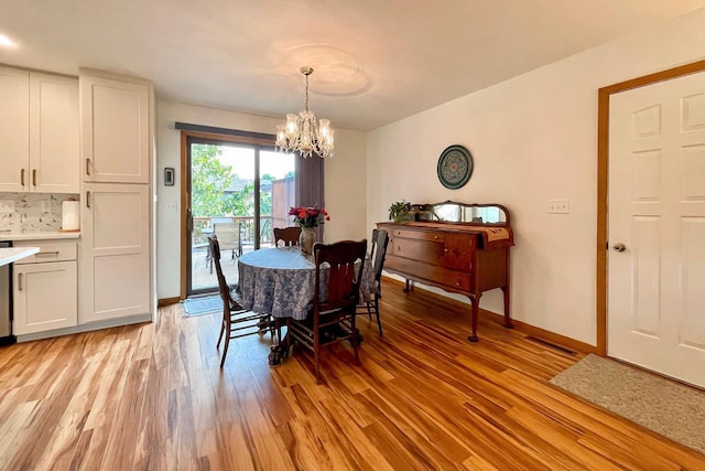 dining space featuring a chandelier, light wood-style flooring, and baseboards