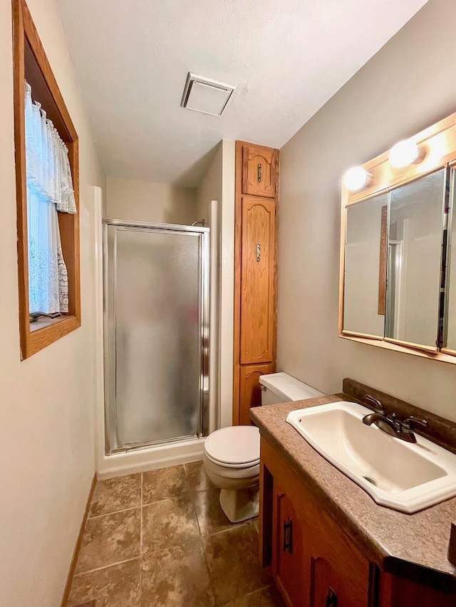 full bathroom with tile patterned floors, toilet, a stall shower, baseboards, and vanity