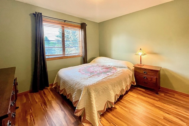 bedroom featuring light wood-style floors and baseboards