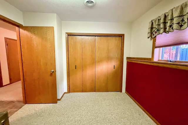 hall featuring visible vents, baseboards, and carpet