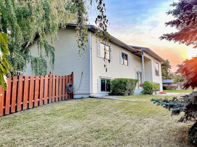 back of property featuring a yard and fence