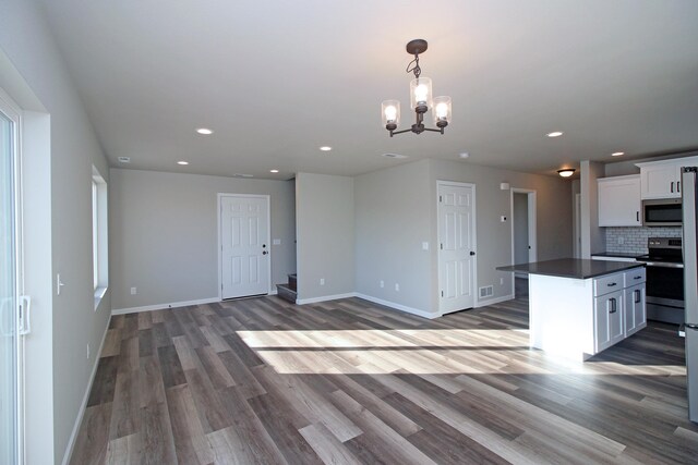 kitchen featuring a kitchen island, stainless steel appliances, hardwood / wood-style floors, and white cabinets