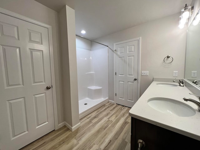 bathroom with vanity, hardwood / wood-style flooring, and walk in shower