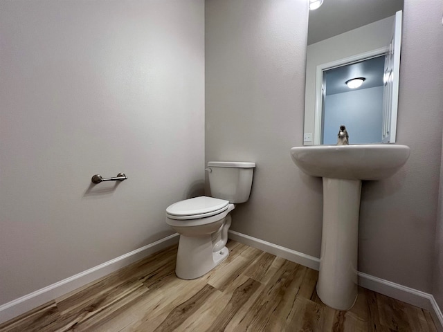 bathroom with hardwood / wood-style floors and toilet