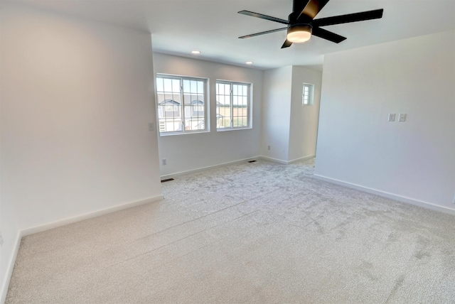 spare room featuring ceiling fan and light colored carpet