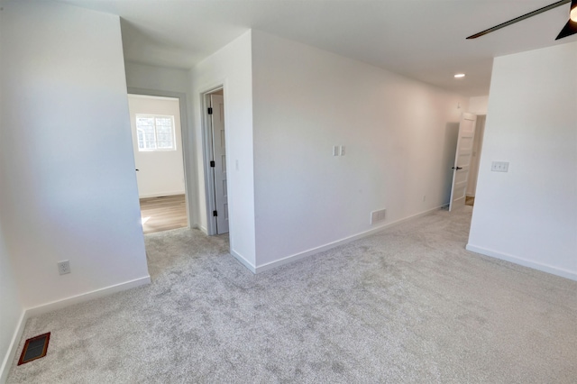 carpeted spare room featuring ceiling fan