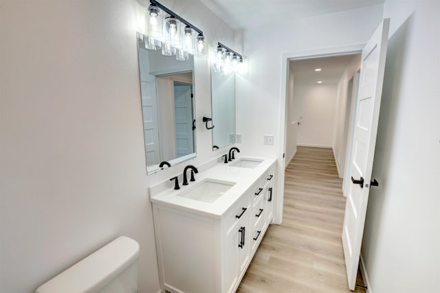 bathroom with vanity, toilet, and hardwood / wood-style floors