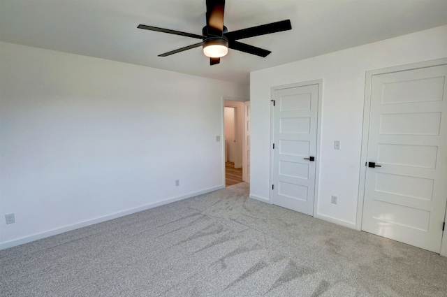 unfurnished bedroom with ceiling fan and light colored carpet