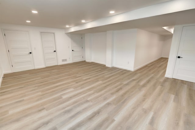 basement with light hardwood / wood-style flooring