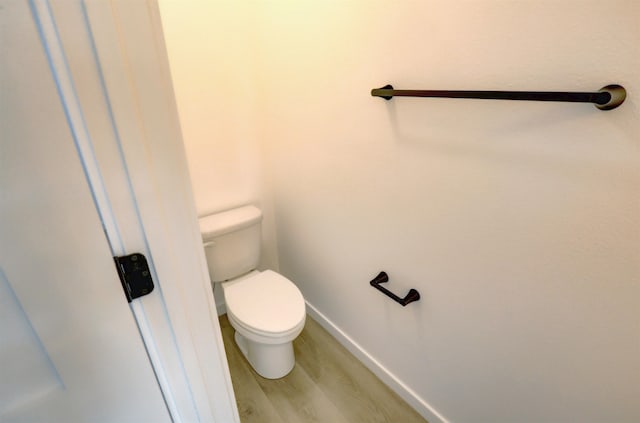 bathroom with hardwood / wood-style floors and toilet