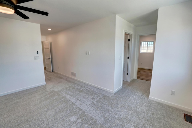 unfurnished room featuring light colored carpet and ceiling fan