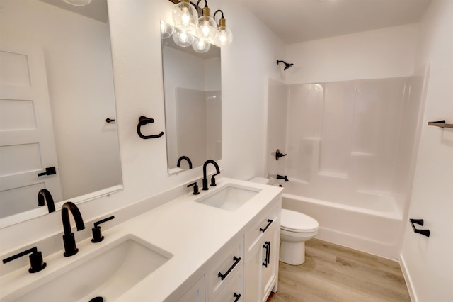 full bathroom featuring vanity, wood-type flooring, toilet, a chandelier, and tub / shower combination