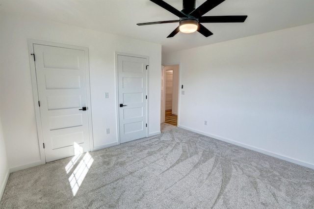 unfurnished bedroom with ceiling fan and light colored carpet