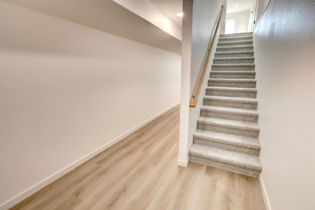 staircase with hardwood / wood-style floors