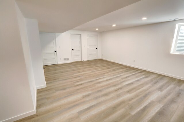 basement with light hardwood / wood-style flooring