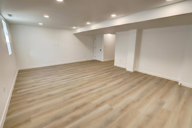 basement with light hardwood / wood-style flooring