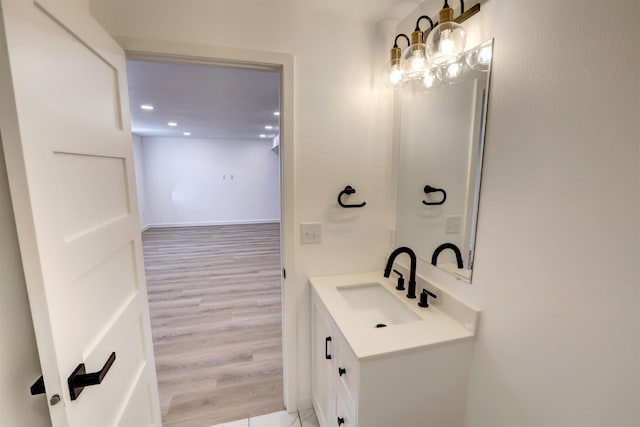 bathroom with hardwood / wood-style flooring, a chandelier, and vanity