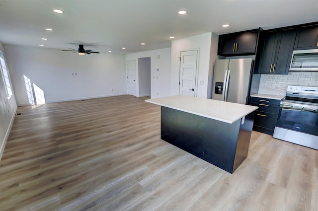 kitchen featuring a center island, stainless steel appliances, light wood-type flooring, and ceiling fan