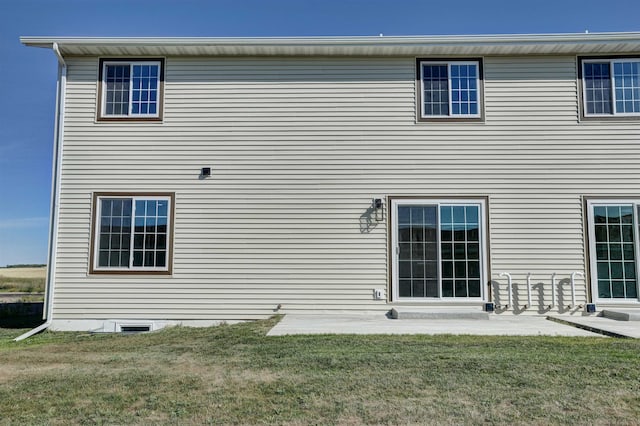 rear view of property with a lawn and a patio area