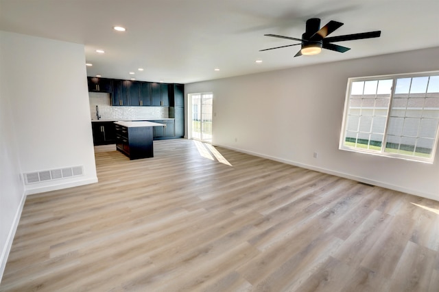 unfurnished living room featuring ceiling fan and light hardwood / wood-style flooring