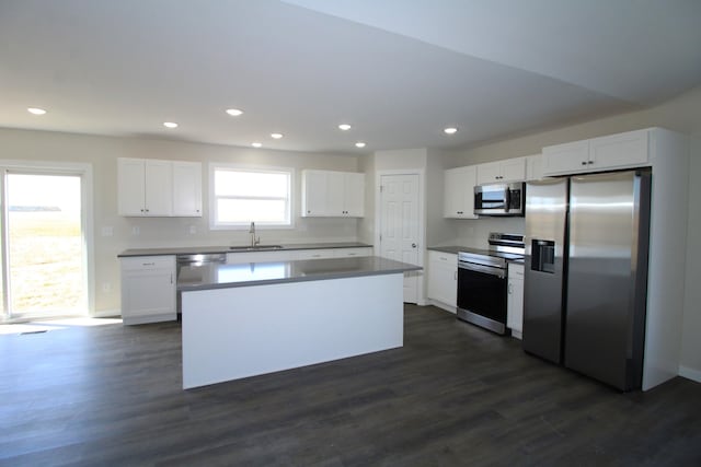 kitchen with dark hardwood / wood-style floors, sink, appliances with stainless steel finishes, and white cabinetry