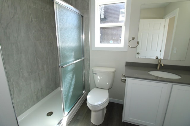 bathroom with vanity, toilet, walk in shower, and hardwood / wood-style floors