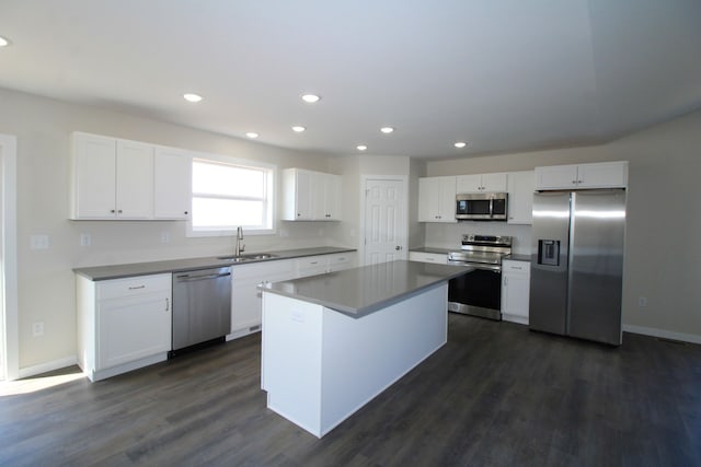 kitchen featuring stainless steel appliances, a center island, sink, dark hardwood / wood-style floors, and white cabinets