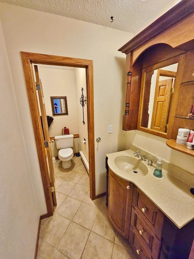 bathroom with toilet, tile patterned floors, vanity, a textured ceiling, and a baseboard heating unit