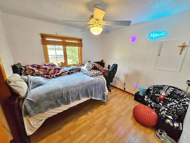 bedroom featuring wood-type flooring, a textured ceiling, and ceiling fan