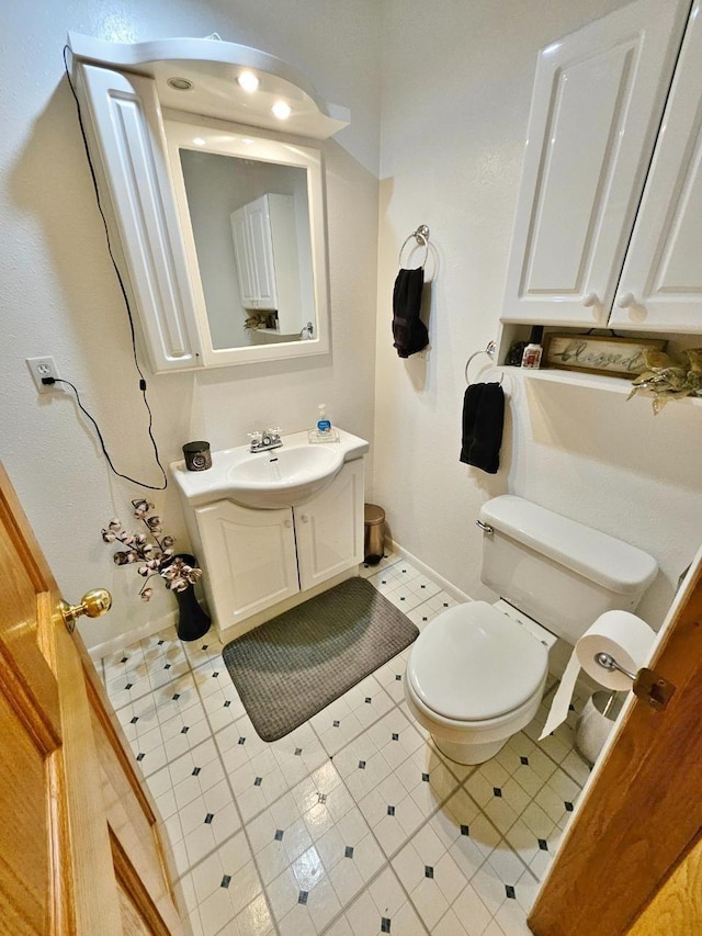 1103 3rd Ave, Rugby, ND 58368 - half bathroom with toilet, vanity, tile patterned floors, and baseboards