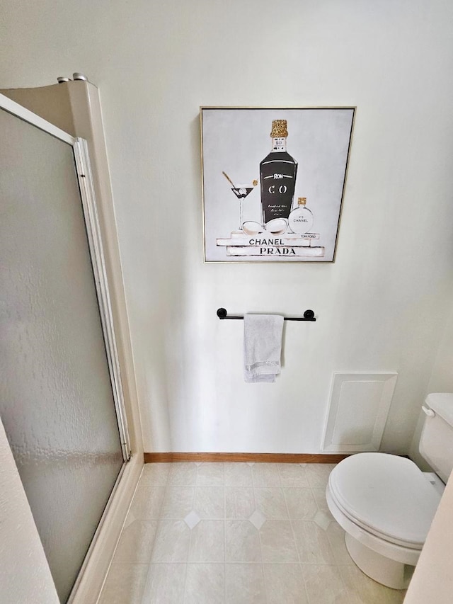 bathroom featuring tile patterned flooring, a shower with shower door, and toilet