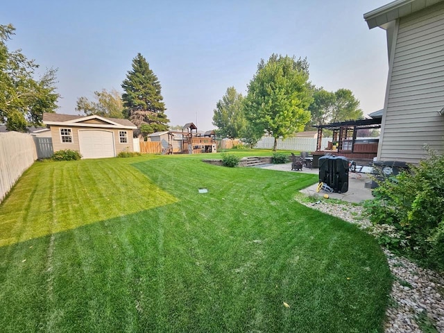 view of yard featuring a patio area, an outdoor structure, a wooden deck, a pergola, and a garage