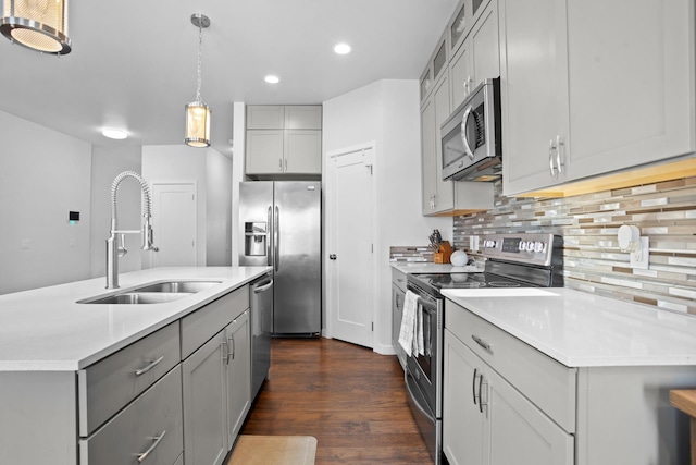 2424 Landmark Dr, Minot, ND 58703 - kitchen with gray cabinetry, a sink, backsplash, stainless steel appliances, and dark wood-style flooring