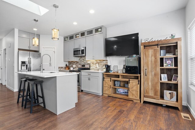 2424 Landmark Dr, Minot, ND 58703 - kitchen with tasteful backsplash, a skylight, dark wood-style floors, stainless steel appliances, and a sink