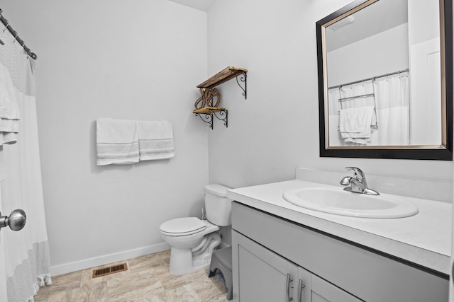 2424 Landmark Dr, Minot, ND 58703 - full bath featuring vanity, toilet, baseboards, and visible vents