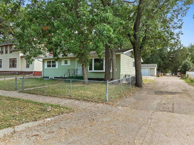 view of front of house featuring an outdoor structure, a garage, and a front lawn