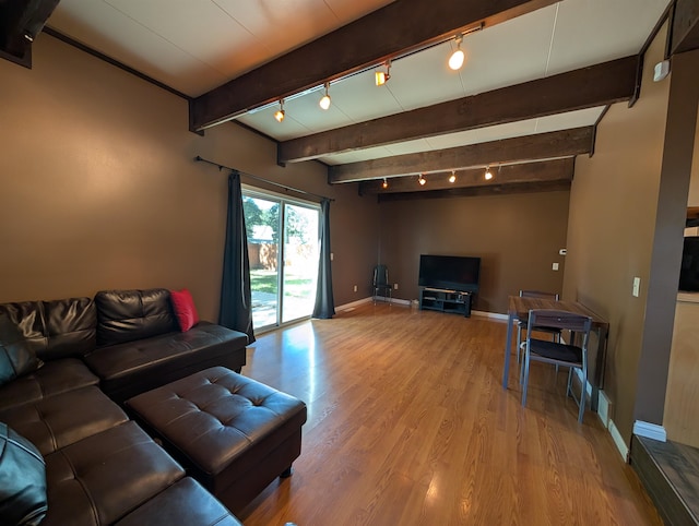 living room with track lighting, beamed ceiling, and light hardwood / wood-style floors