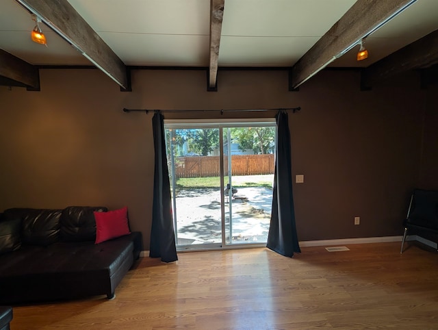 interior space with wood-type flooring and beam ceiling