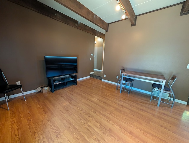 sitting room featuring light wood-type flooring and beam ceiling