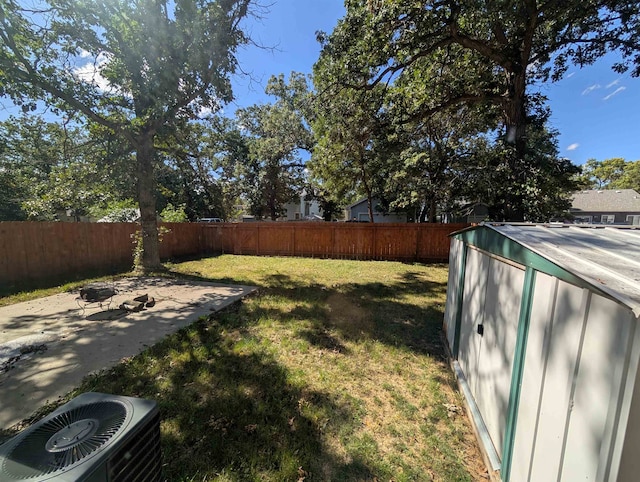 view of yard featuring a storage shed, central AC unit, and a patio area