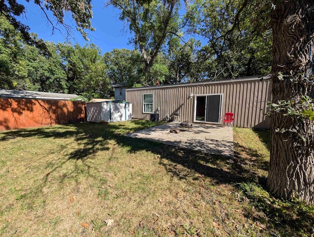 view of yard featuring a storage unit and a patio