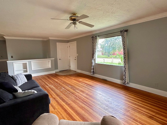 living room with light hardwood / wood-style flooring, a textured ceiling, ceiling fan, and crown molding