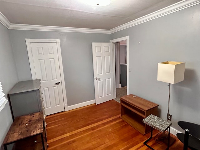 living area with hardwood / wood-style floors and crown molding