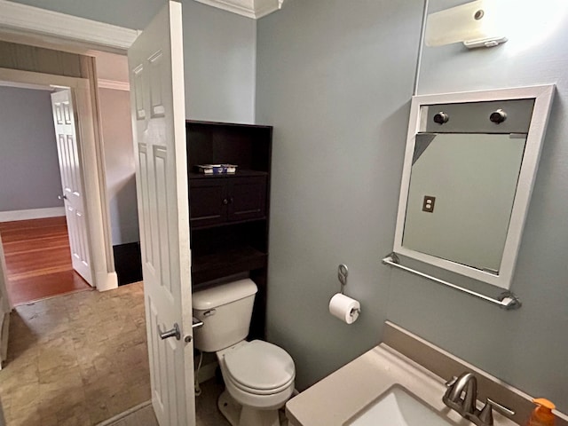 bathroom with ornamental molding, sink, hardwood / wood-style floors, and toilet