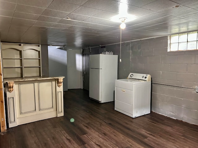 basement with washer / dryer, white refrigerator, and dark hardwood / wood-style floors