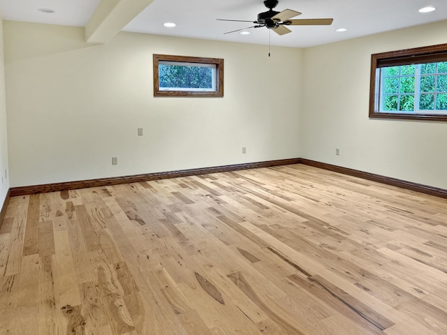 spare room with ceiling fan, beamed ceiling, and light hardwood / wood-style floors