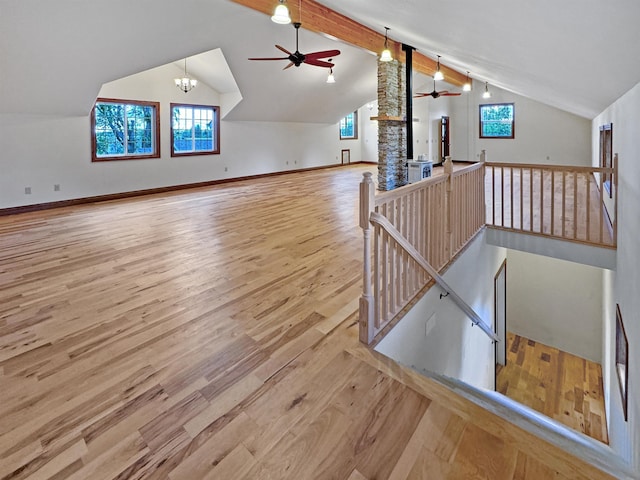 additional living space featuring ceiling fan with notable chandelier, lofted ceiling with beams, light hardwood / wood-style floors, and a wealth of natural light