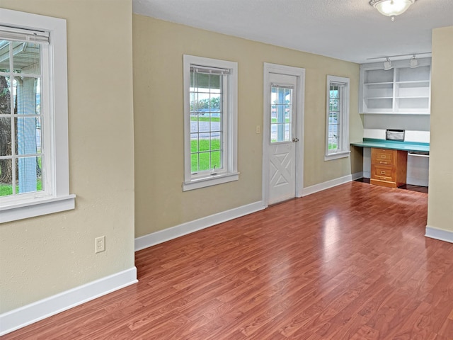 entryway featuring built in desk, a textured ceiling, and hardwood / wood-style floors