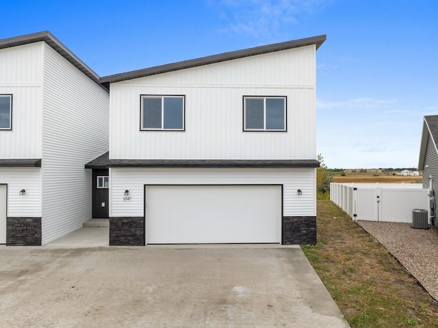 view of front of house featuring a garage and central AC