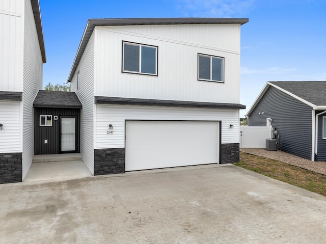 view of front of house featuring central air condition unit and a garage